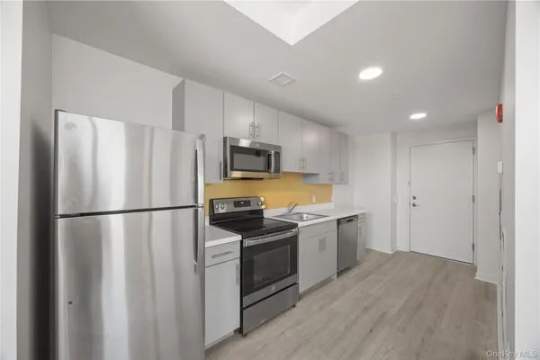 a kitchen with a refrigerator a stove top oven a sink and dishwasher