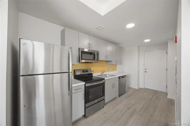 a kitchen with a refrigerator a stove top oven a sink and dishwasher