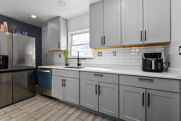 a kitchen with white cabinets and refrigerator