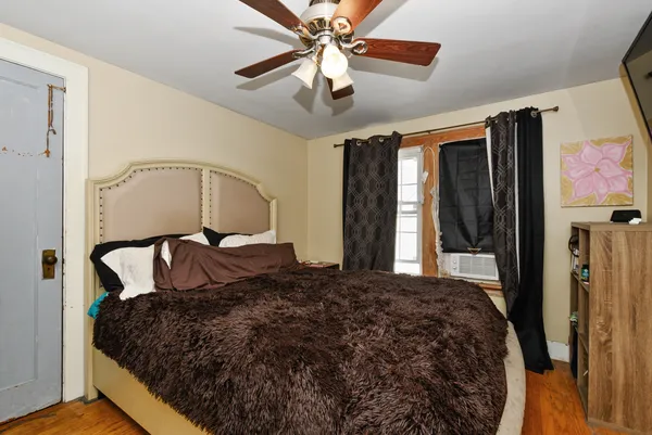 a bedroom with a bed dresser and a window