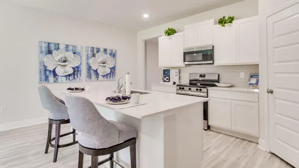 a kitchen with stainless steel appliances a sink a stove a table and chairs
