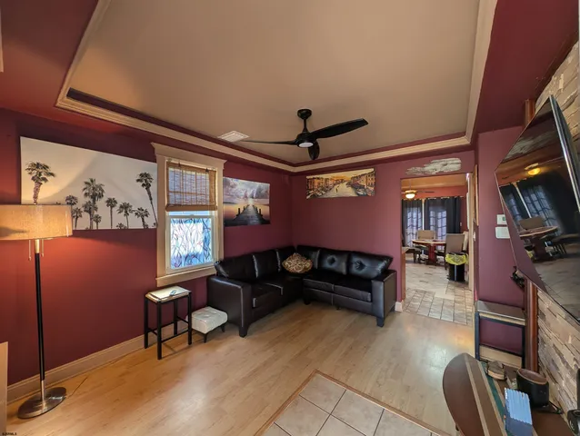 a living room with furniture a flat screen tv and a window