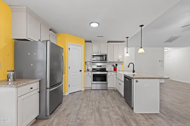a kitchen with white cabinets and stainless steel appliances