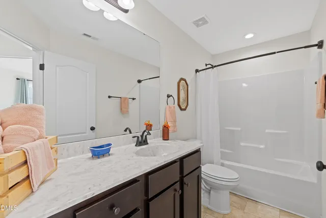 a bathroom with a granite countertop sink a toilet and shower