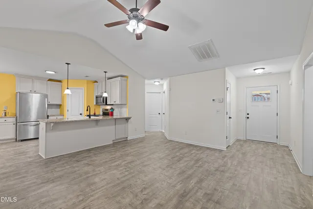 a view of a kitchen with kitchen island stainless steel appliances refrigerator stove microwave and cabinets
