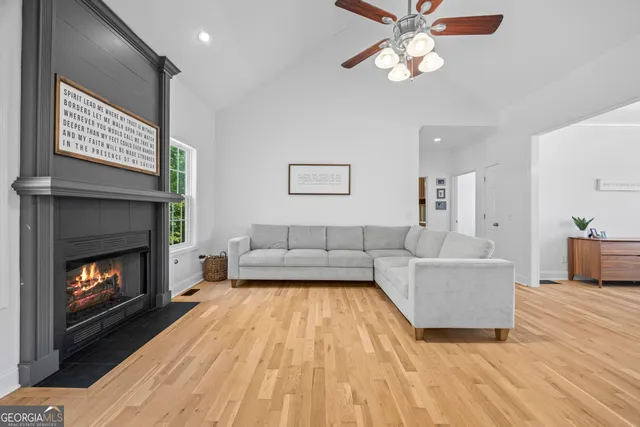 a kitchen with kitchen island a counter top space a sink a refrigerator and wooden floor