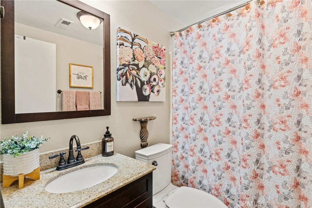 7615 Canberra Way Riverside, CA 92508 - Photo 15 of 37 a bathroom with a sink and a mirror with toilet