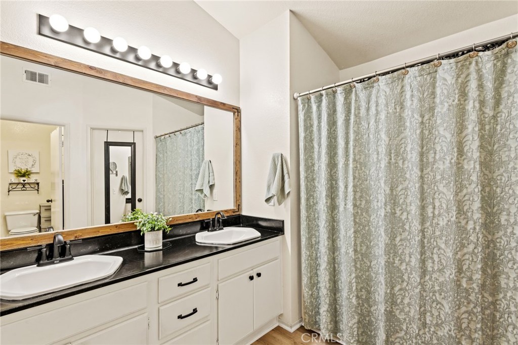 7615 Canberra Way Riverside, CA 92508 - Photo 18 of 37 a bathroom with a double vanity sink and mirror