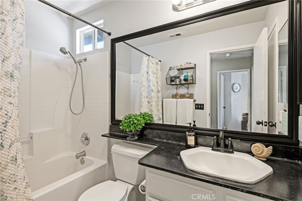 7615 Canberra Way Riverside, CA 92508 - Photo 21 of 37 a bathroom with a granite countertop sink mirror toilet and bathtub