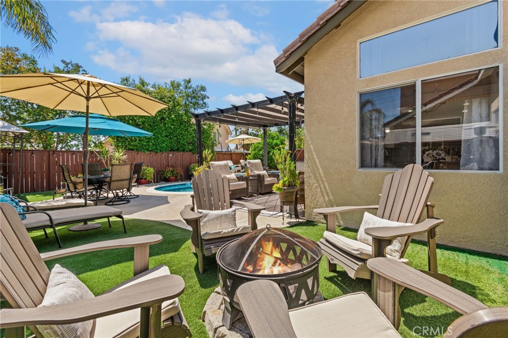 7615 Canberra Way Riverside, CA 92508 - Photo 25 of 37 a view of a patio with couches table and chairs under an umbrella with a barbeque