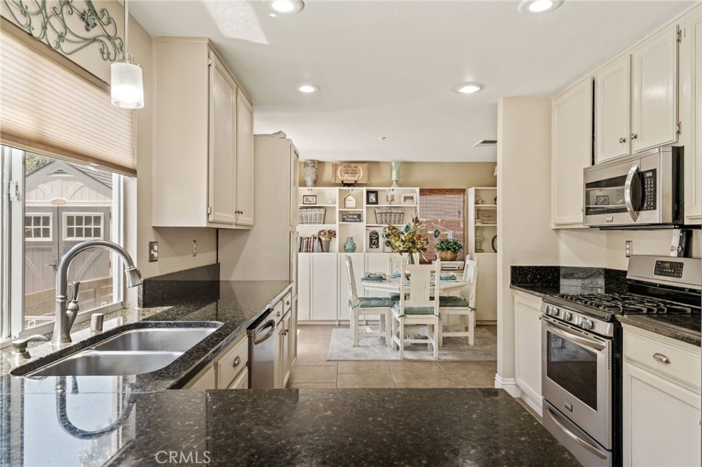 7615 Canberra Way Riverside, CA 92508 - Photo 10 of 37 a kitchen with granite countertop a stove a sink and a microwave