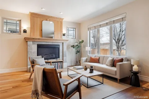 a living room with furniture a fireplace and a large window
