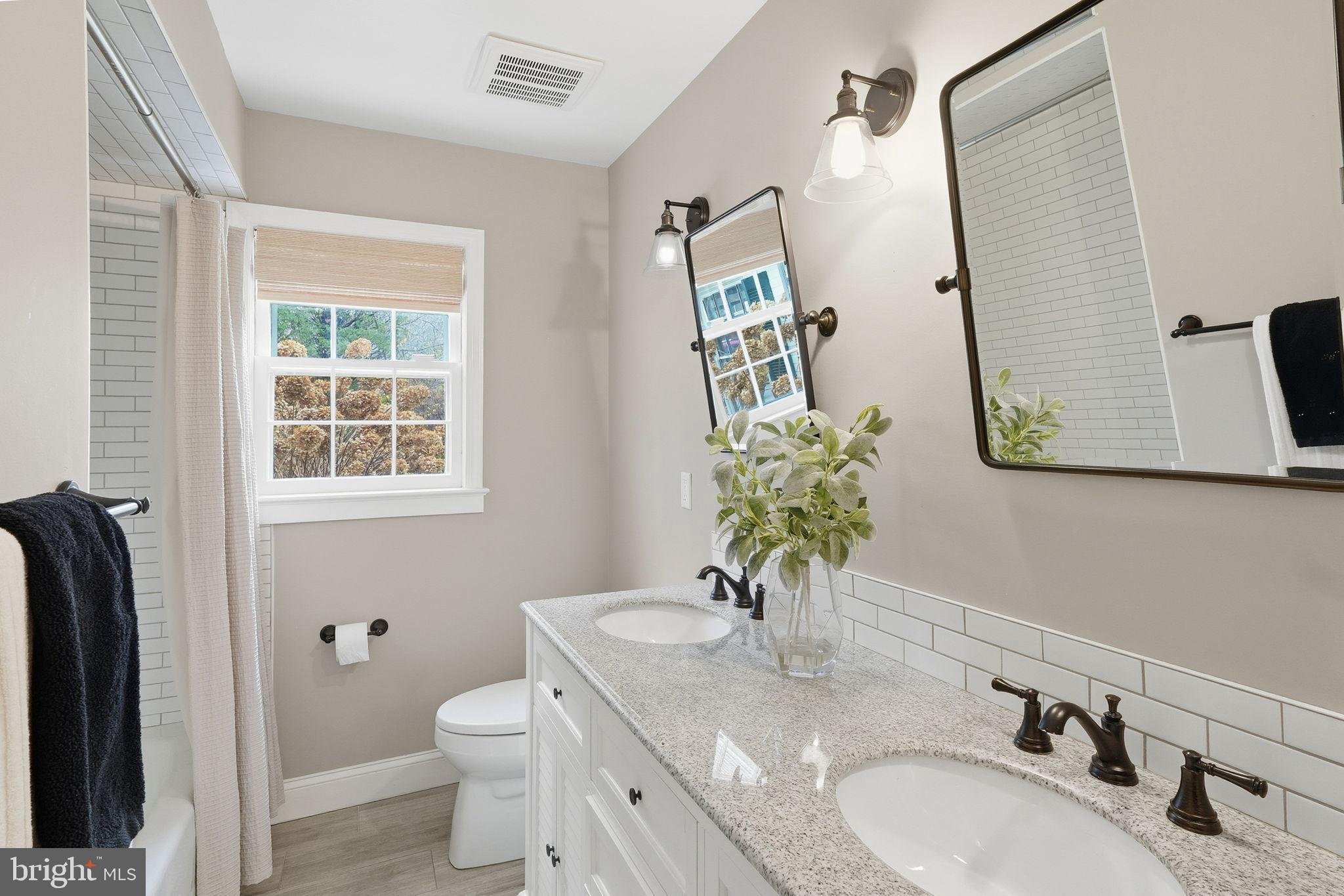 8436 Burning Tree Road Bethesda, MD 20817 - Photo 14 of 34 a bathroom with a granite countertop sink and a mirror
