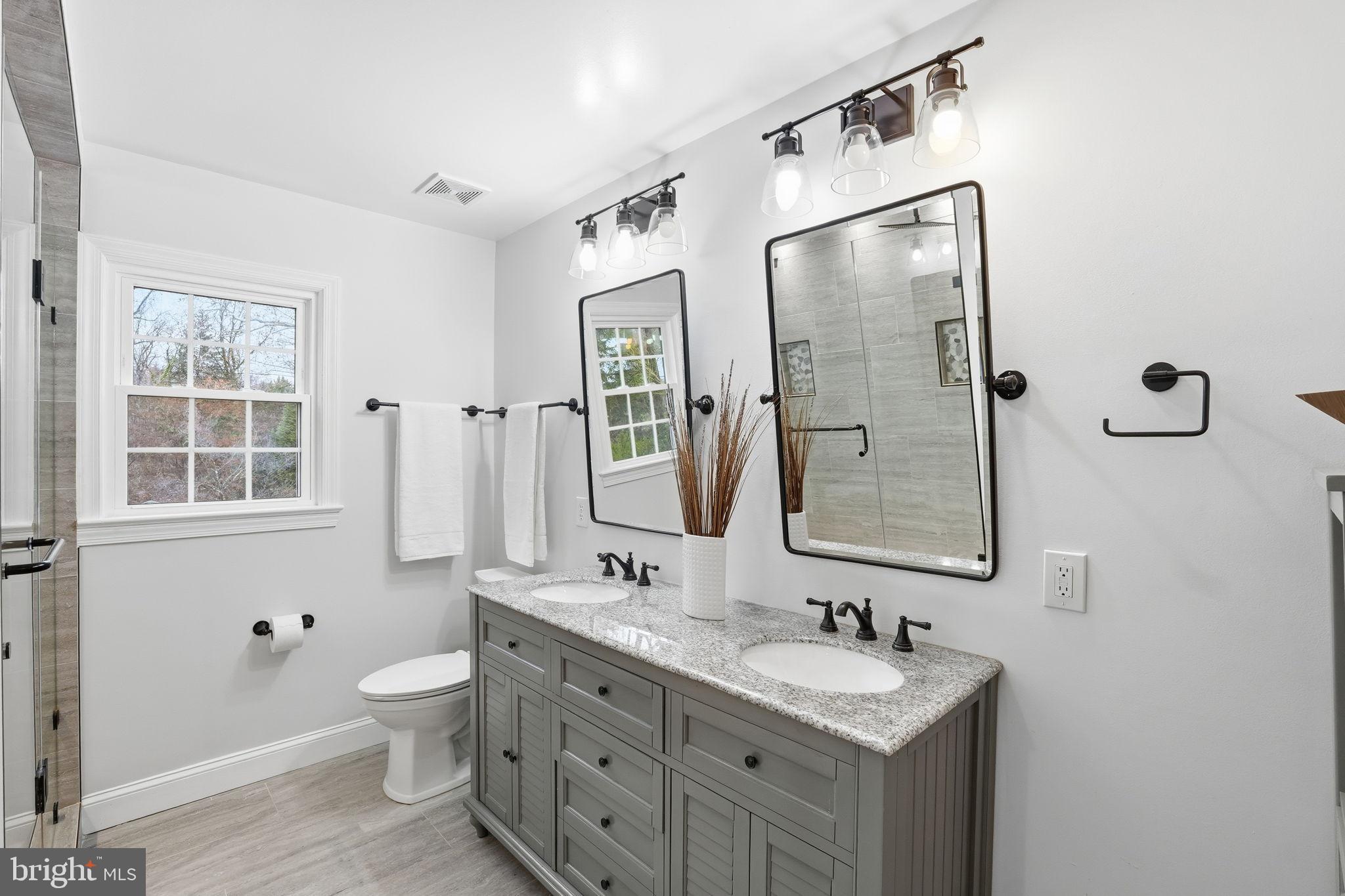 8436 Burning Tree Road Bethesda, MD 20817 - Photo 20 of 34 a bathroom with a double vanity sink mirror and toilet