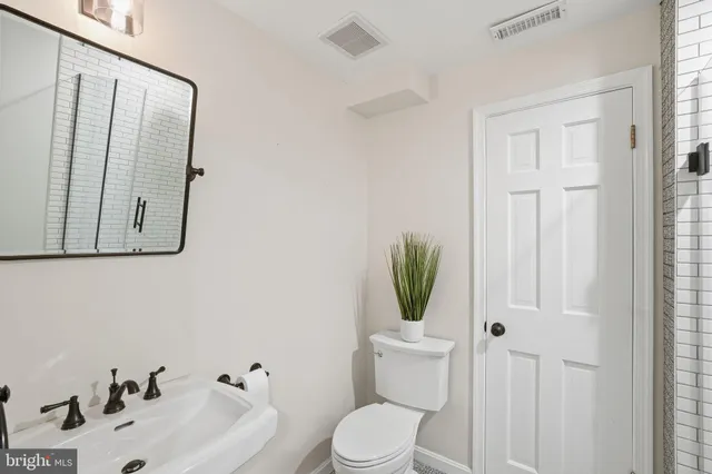 a bathroom with a toilet sink and mirror