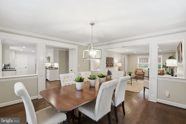 a view of a dining room and livingroom furniture wooden floor a rug and a chandelier