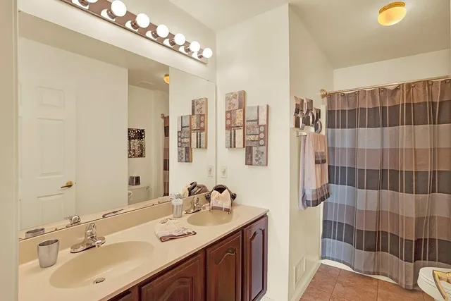 a bathroom with a double vanity sink mirror and shower