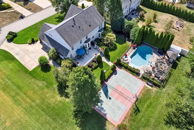 an aerial view of residential houses with outdoor space and parking