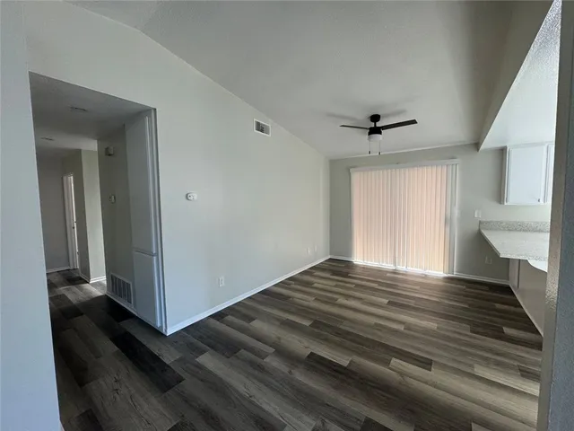 a view of a livingroom with wooden floor and a ceiling fan