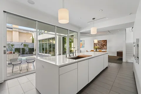 a large white kitchen with a large window