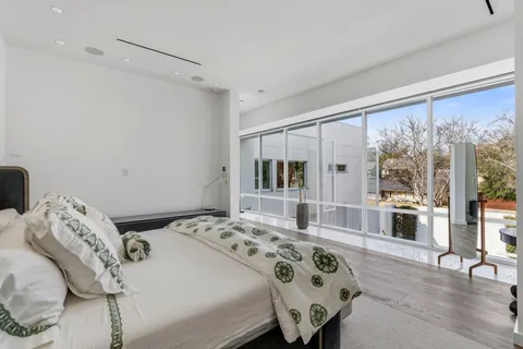 a bedroom with a bed and a large window