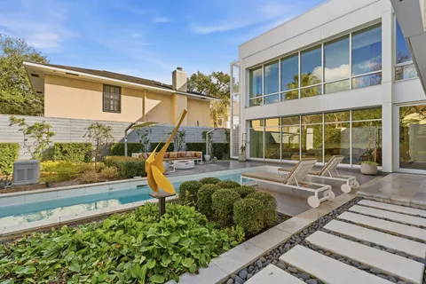 a view of a house with backyard sitting area and swimming pool