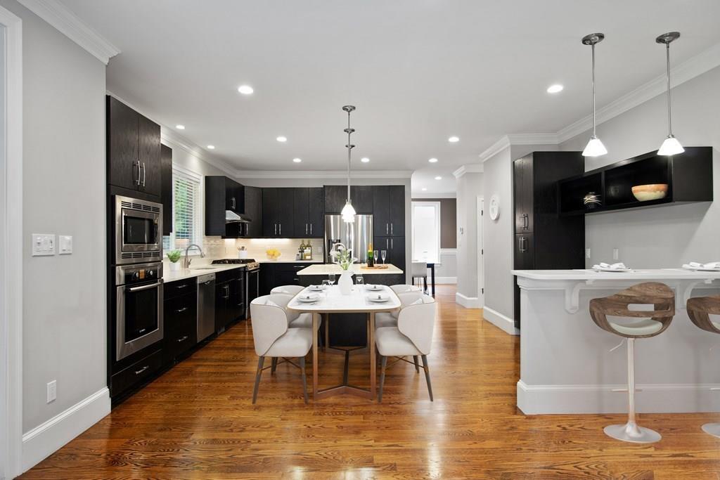 45 Village Circle Newton, MA 02459 - Photo 4 of 18 a kitchen with stainless steel appliances kitchen island granite countertop a refrigerator a stove a sink and a dining table with wooden floor