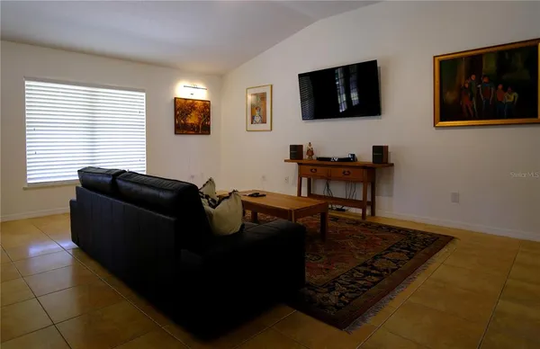a kitchen with stainless steel appliances granite countertop a refrigerator a stove a sink a dining table and chairs