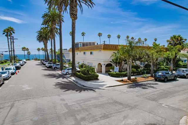 a view of a street with a building and palm tree