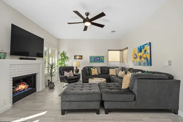 a living room with furniture a flat screen tv and a fireplace