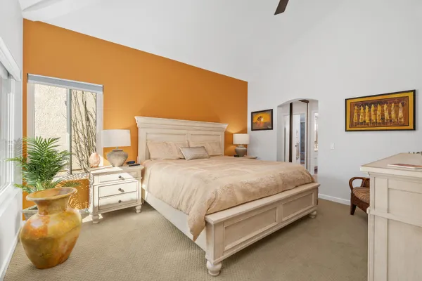 a bedroom with a bed and a potted plant