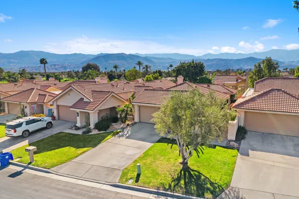 an aerial view of a house with a garden and lake view