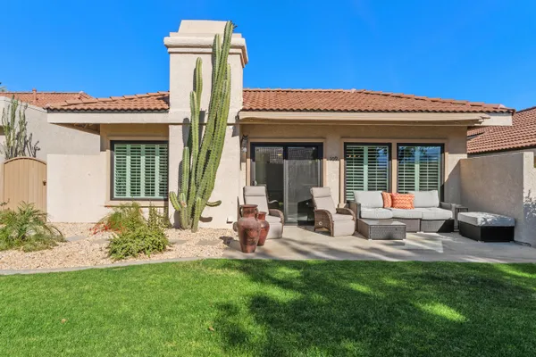 a view of a house with backyard sitting area and porch