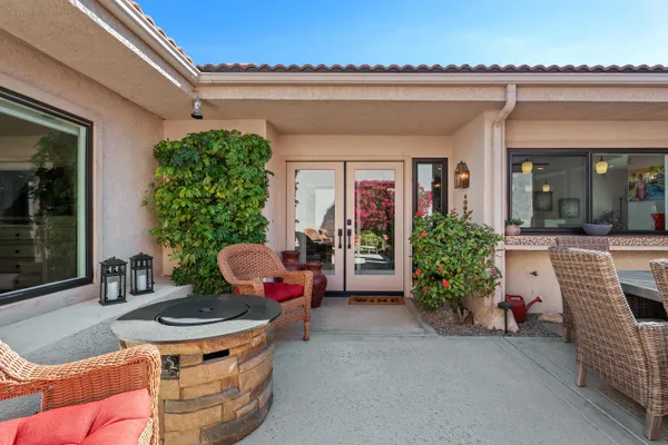 a view of a patio with couches table and chairs and potted plants