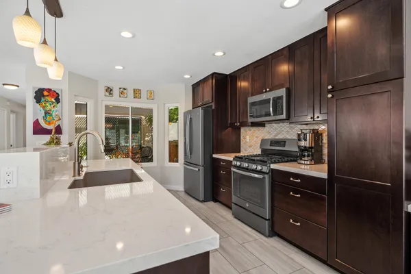 a kitchen with stainless steel appliances granite countertop a refrigerator and a stove top oven