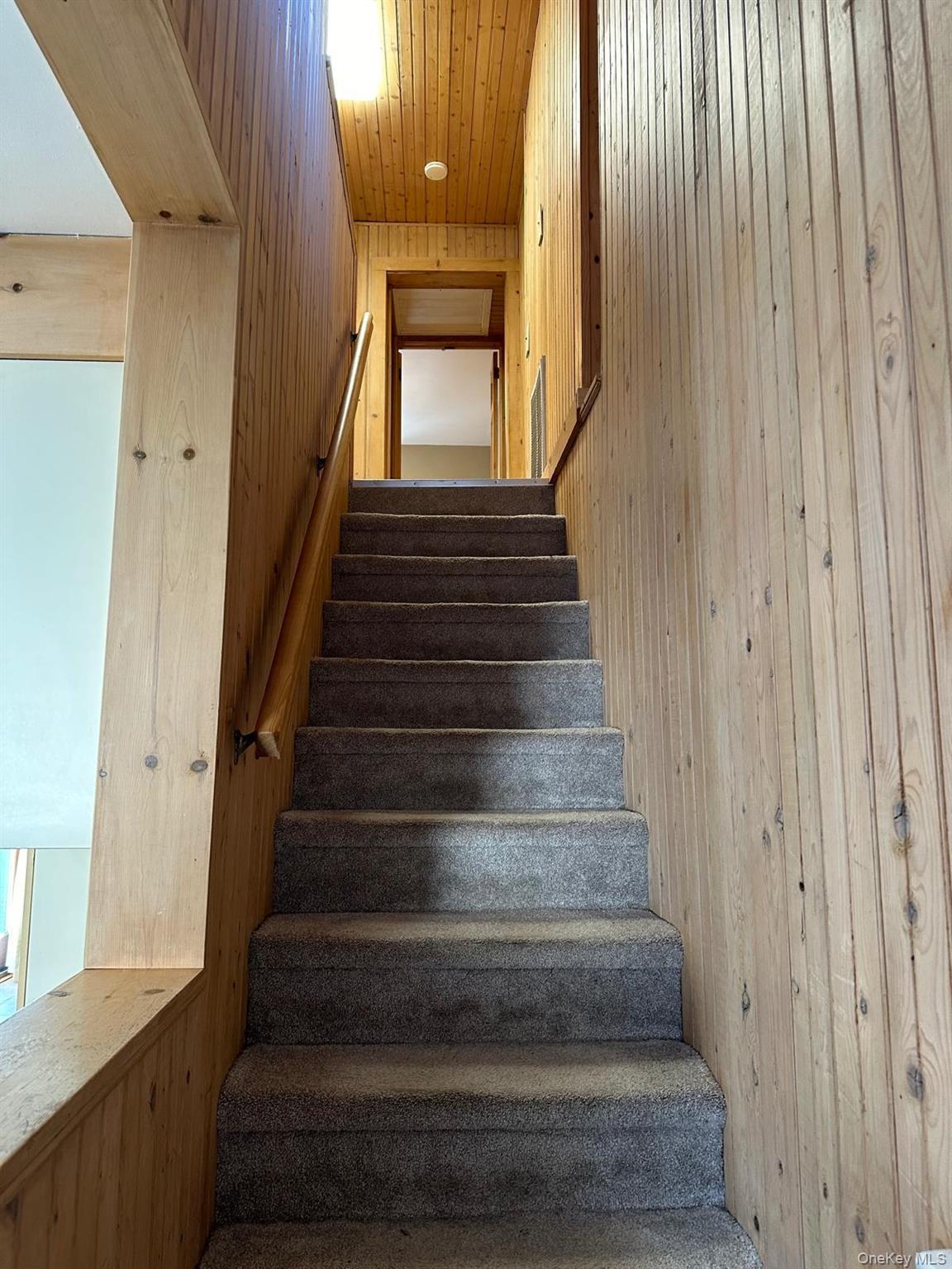 168 Pine Hill Road, Unit 1 Chester, NY 10918 - Photo 6 of 13 Stairway featuring wood ceiling and wooden walls leading to 2nd floor