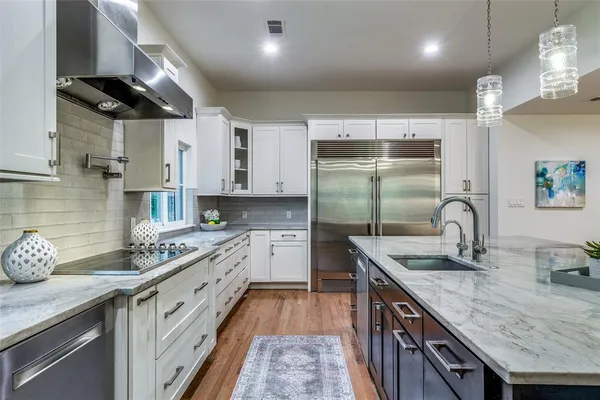 a kitchen with granite countertop a sink stainless steel appliances and cabinets
