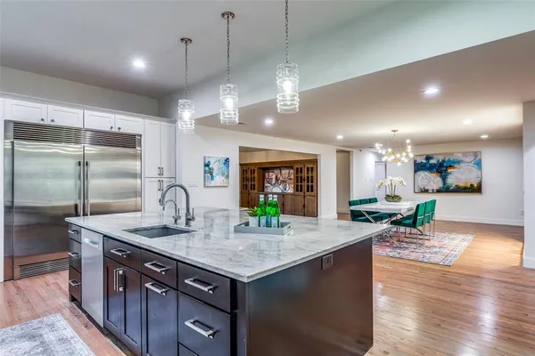 a kitchen with a stove a refrigerator and a sink with wooden floor