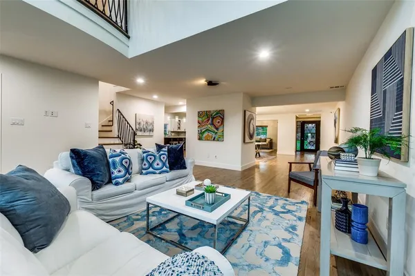 a living room with furniture and a wooden floor