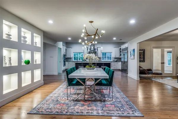 a view of a dining room with furniture a rug and wooden floor