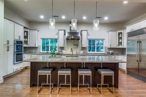 a kitchen with kitchen island granite countertop a table chairs sink and microwave