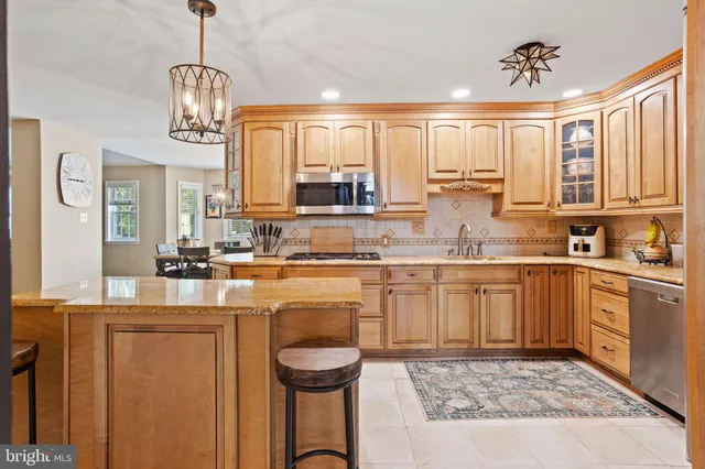 a kitchen with kitchen island granite countertop a sink cabinets and window