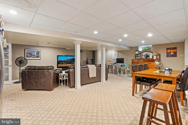 a room with furniture a flat screen tv and a refrigerator