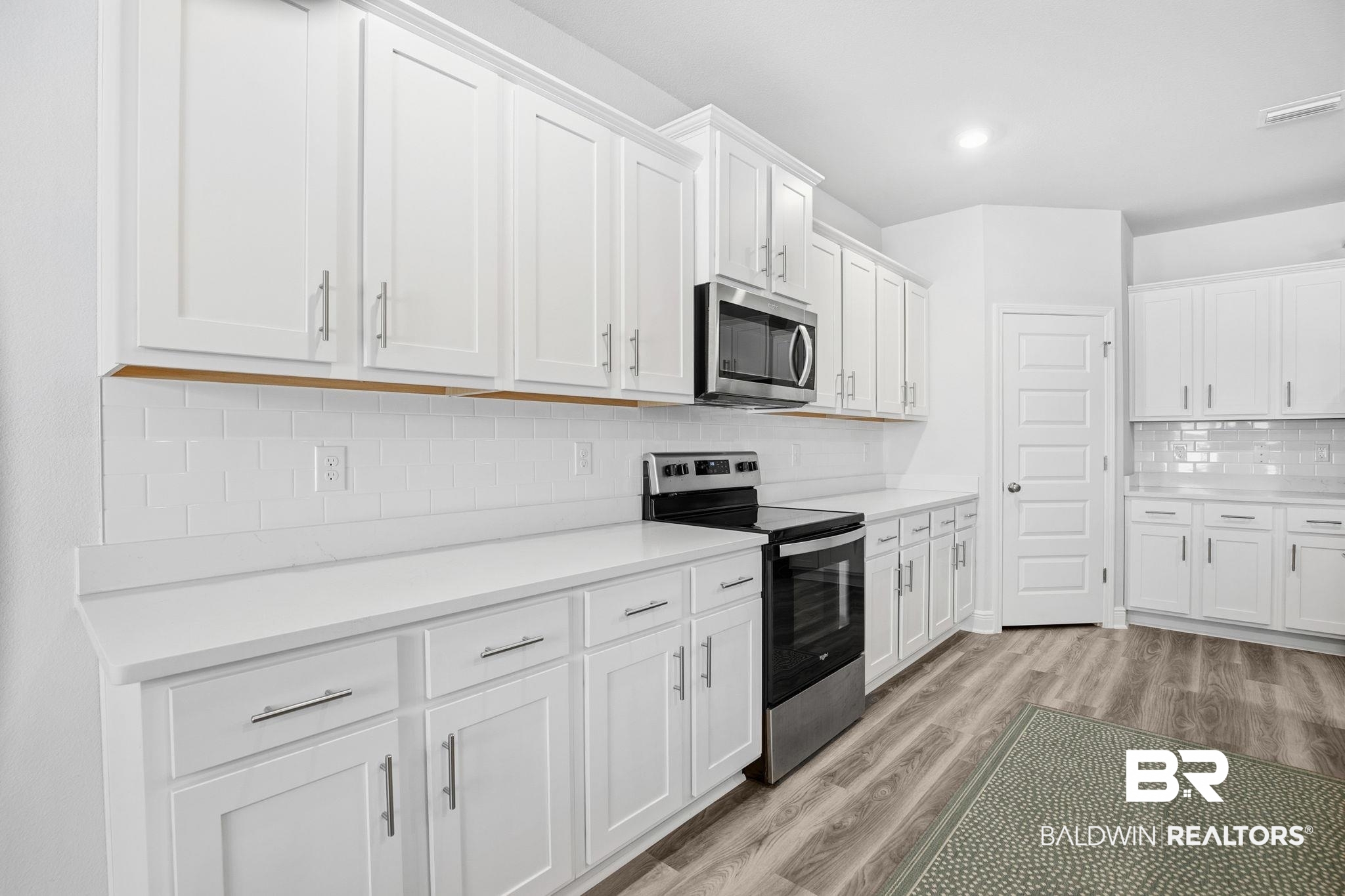 11123 Genuine Risk Circle Daphne, AL 36526 - Photo 18 of 67 Kitchen with stainless steel appliances, white cabinetry, light wood-type flooring, and decorative backsplash