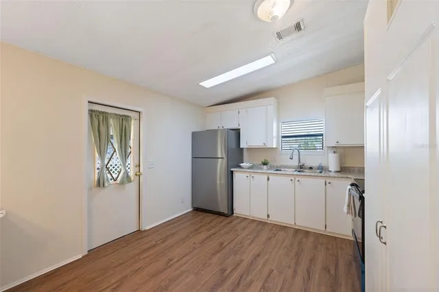a kitchen with refrigerator cabinets and wooden floor