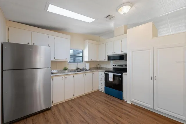 a kitchen with stainless steel appliances a refrigerator sink and microwave