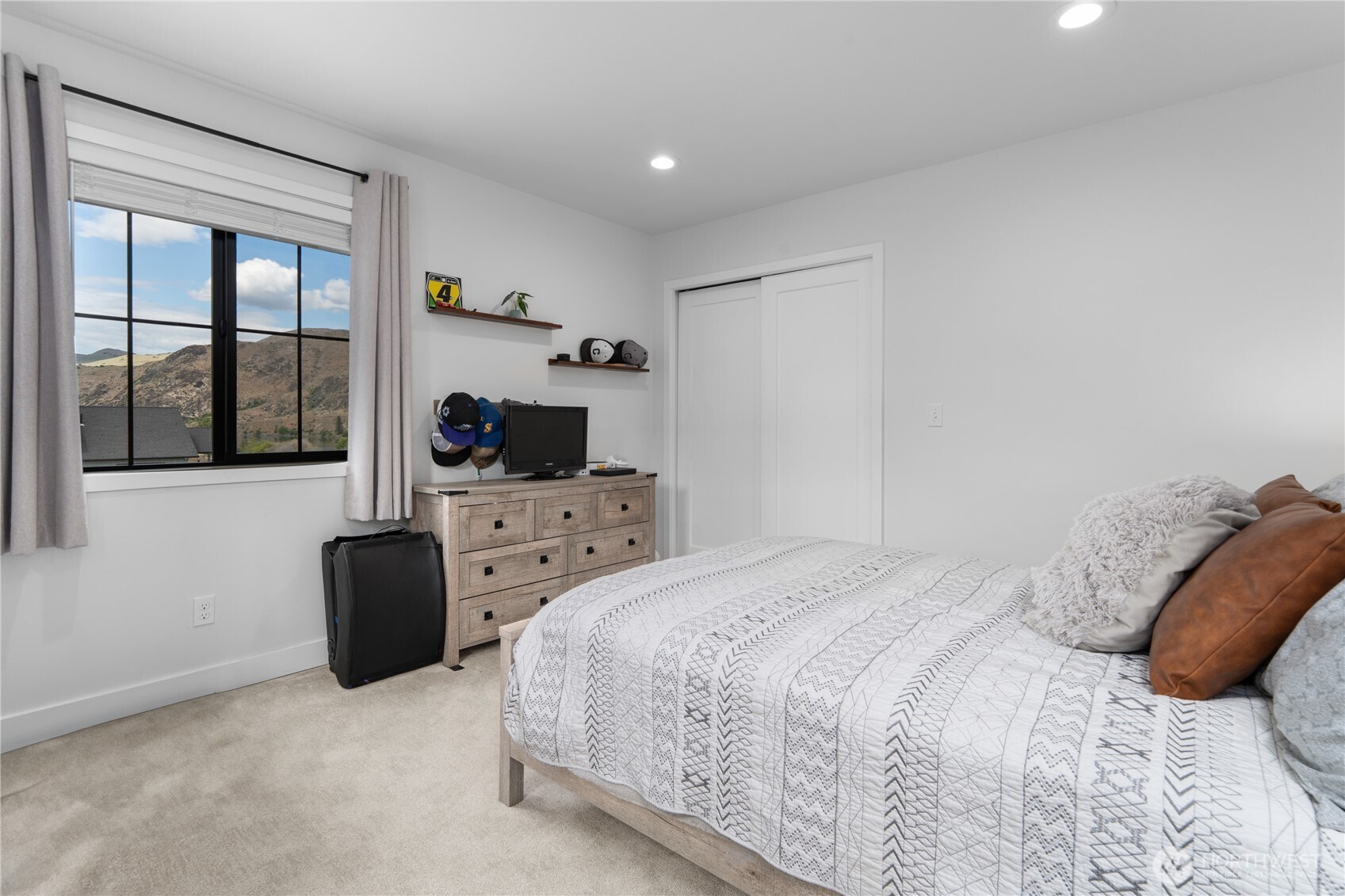 485 Hidden Lane Chelan, WA 98816 - Photo 20 of 40 a bedroom with a bed flat screen tv and windows