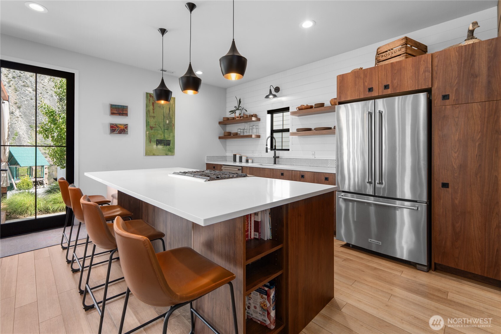 485 Hidden Lane Chelan, WA 98816 - Photo 7 of 40 a kitchen with stainless steel appliances a stove a refrigerator a sink a dining table and chairs with wooden floor