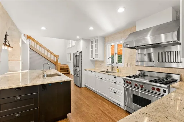 a kitchen with granite countertop a sink stainless steel appliances and cabinets