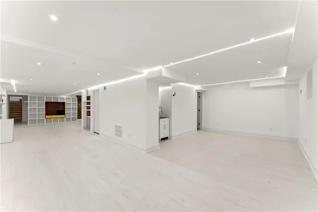 a view of an empty room with a window and fireplace